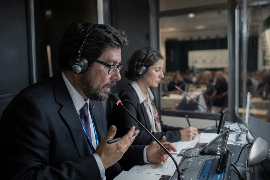 Dois intérpretes profissionais trabalhando com headsets em cabine